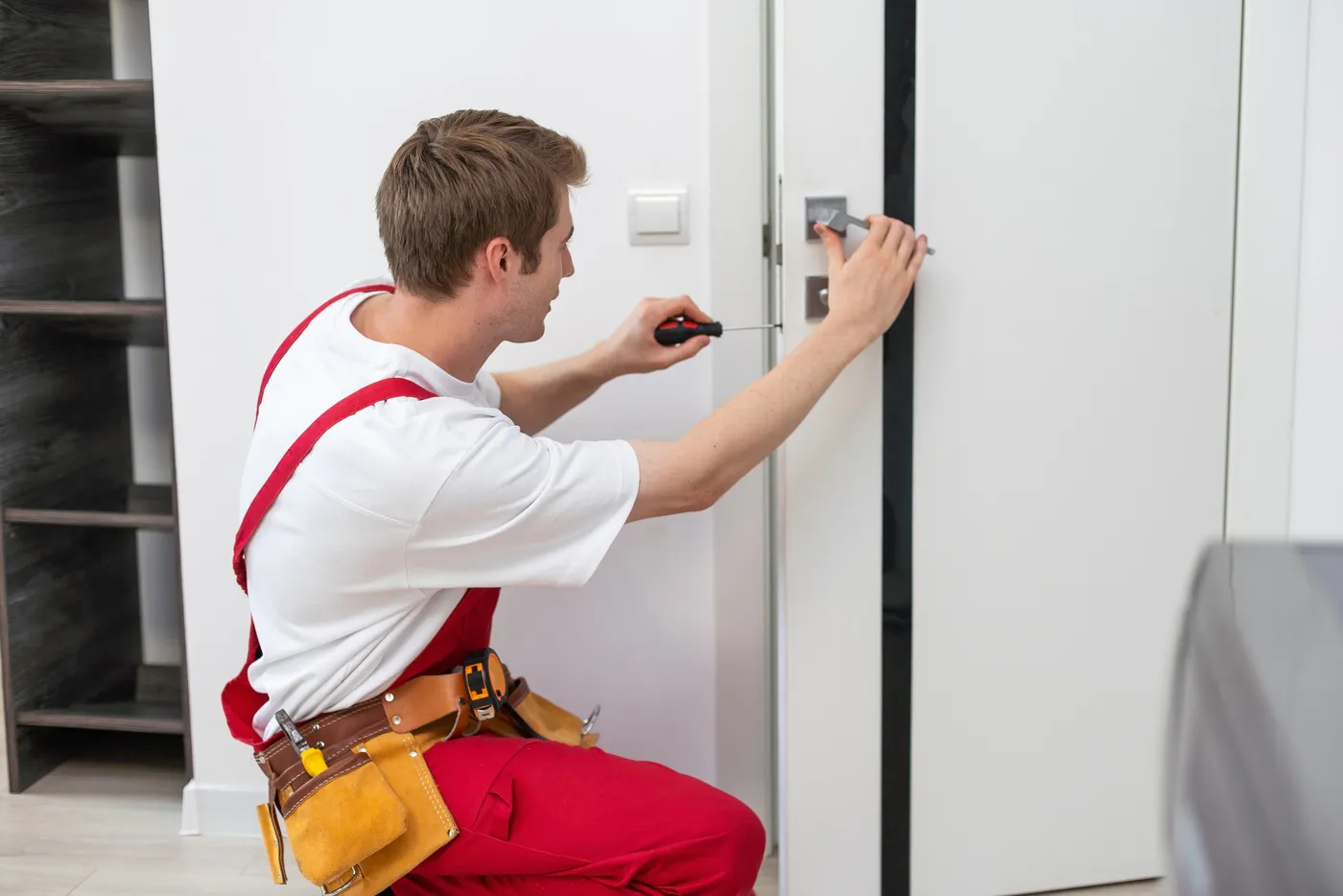 Artisan serrurier posant une serrure sur une porte d'appartement à Paris